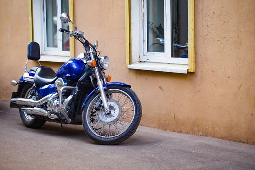 blue motorcycle parked near the house
