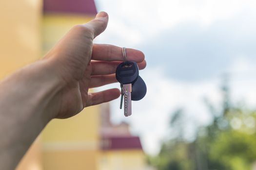 the guy holds the keys in hand close up