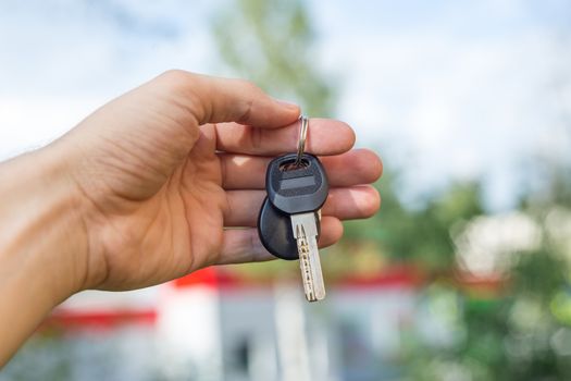 the guy holds the keys in hand close up