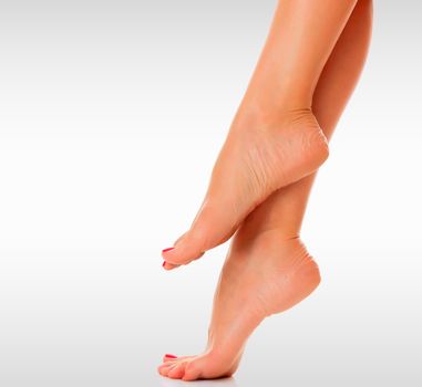 Female feet against a grey background with copyspace