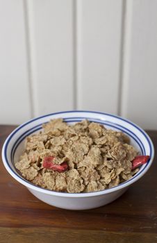 Dry corn flakes with sliced strawberries mixed in