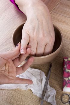 Master in manicure uses a special manicure tool in the beauty salon