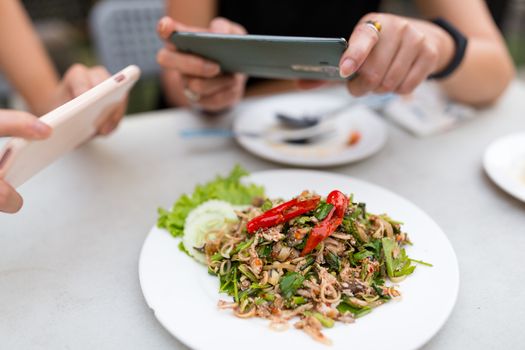 People taking photo on food with mobile phone