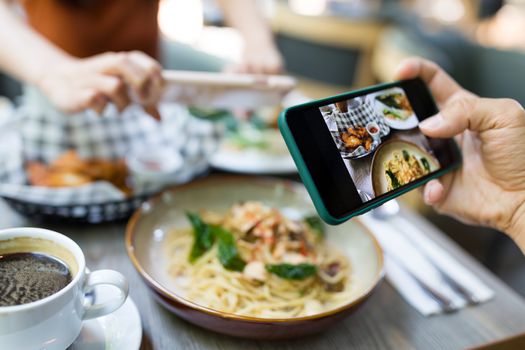 Friends taking photo on dish in restaurant