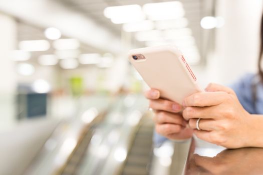 Woman working on cellphone in a station