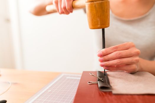 Woman making leather bag