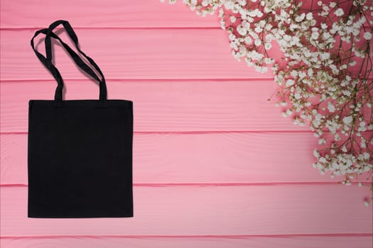 black cotton bag for shopping on a pink wooden background