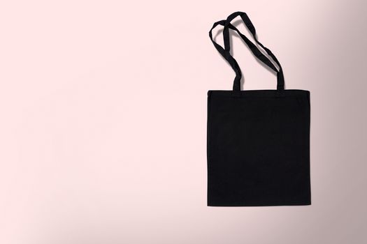 black cotton bag for shopping on a pink background