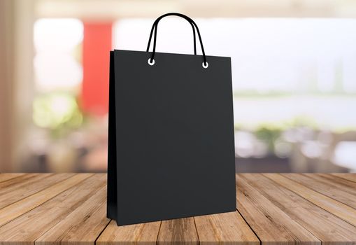 black paper bag for shopping on a wooden background