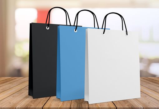 Three paper bags for shopping on a wooden background