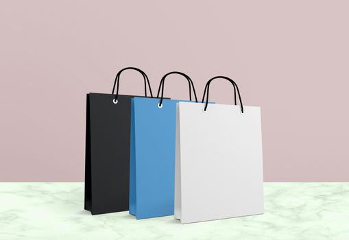 three paper bags for shopping on a pink background