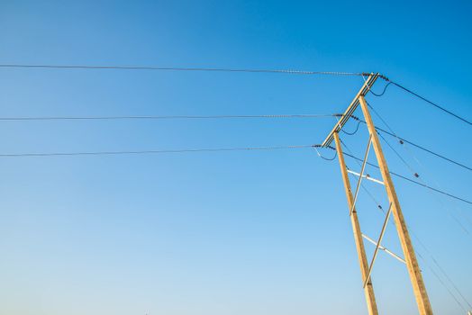 Electricity post and a blue sky background.
