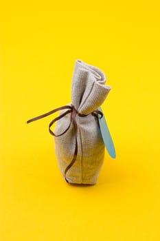 sack made of burlap on brown tie on a yellow background