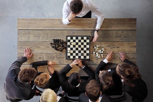 Business people playing chess, team of workers losing, leader is winning