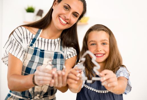 Shot of a mother and daughter having fun in the kitchen and learning to make a cake