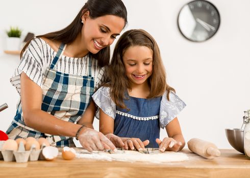 Shot of a mother and daughter having fun in the kitchen and learning to make a cake