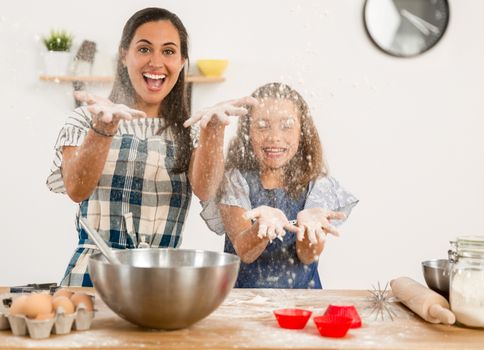 Shot of a mother and daughter having fun in the kitchen and learning to make a cake