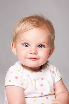 Adorable cute happy blue eyed baby infant face with blond hair.