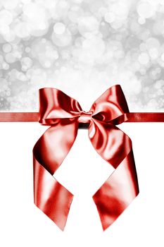 Red gift ribbon bow and bokeh lights isolated on white background