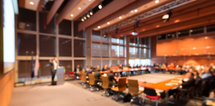 Speaker giving a talk on corporate business event. Audience at the conference hall. Business and Entrepreneurship event. Out of focus image. Unrecognizable business people.