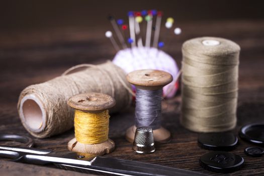 Sewing instruments, threads, needles, bobbins and materials. Studio photo