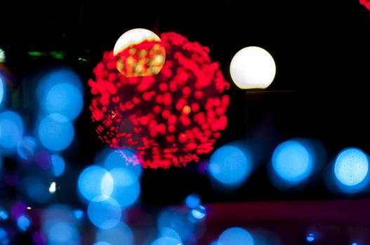 blury christmas red ball and blue lights in foreground and white lights in backround