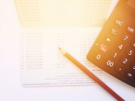 Business, finance, savings or mortgage background concept ; Pen, calculator and savings account passbook on white background