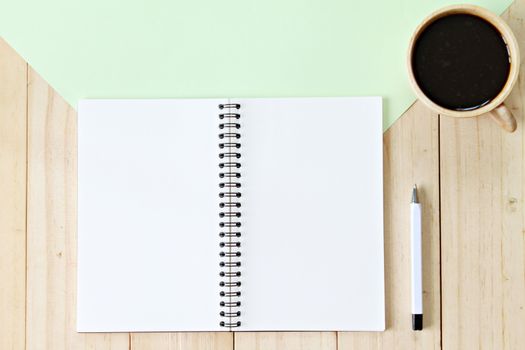 Still life, business, office supplies or education concept : Top view image of open notebook with blank pages and coffee cup on wooden background, ready for adding or mock up