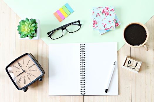 Business, weekend, holiday or new year planning concept : Top view or flat lay of open notebook paper, accessories, cube calendar and coffee cup on wooden background, ready for adding or mock up