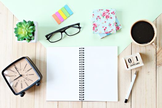 Business, weekend, holiday or new year planning concept : Top view or flat lay of open notebook paper, accessories, cube calendar and coffee cup on wooden background, ready for adding or mock up