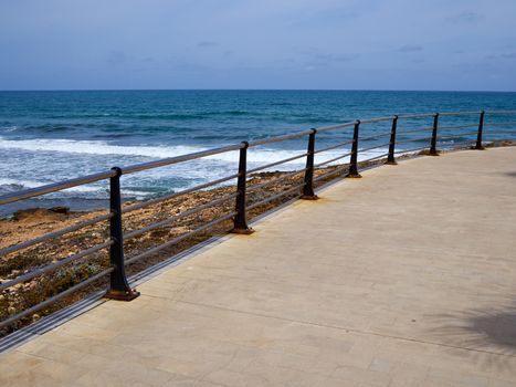Beautiful beach seaside promenade with metal railings summer vacation attraction Spain