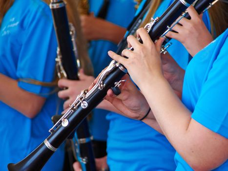 Young woman musician playing clarinet as part of a big orchestra