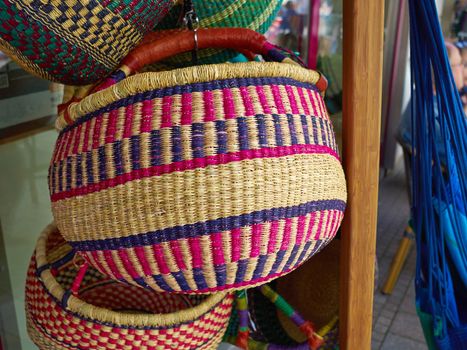 Colorful woven handmade classical traditional African Caribbean baskets for sale in a market  