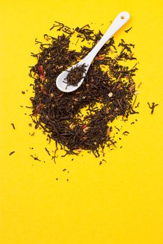 Tea composition with spoon on yellow background
