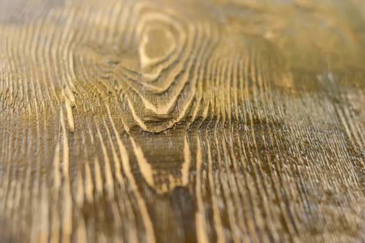 Background of a surface of the old wooden plank darkened with time at shallow depth of field
