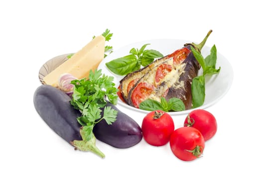 Baked eggplant stuffed with vegetables and cheese decorated with basil leaves on white dish and ingredients for its cooking beside on a white background
