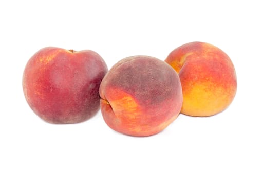 Three ripe fresh peaches on a white background
