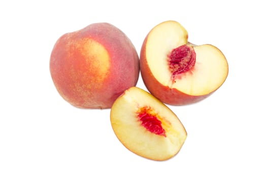One whole and one cut into slices ripe fresh peaches on a white background
