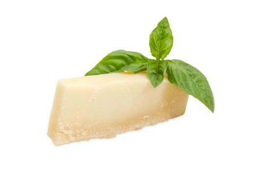 Piece of the parmesan cheese and twig of green basil on a white background
