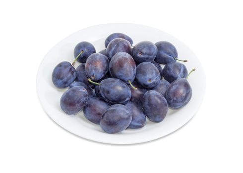 Ripe plums on the white dish closeup on a white background
