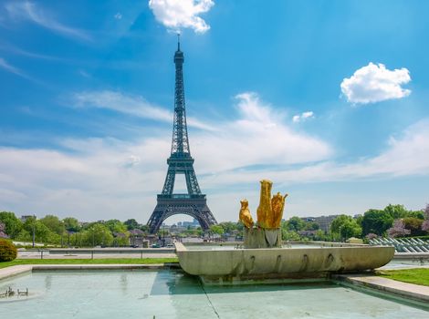 View of the Eiffel Tower from the Trocadero Square with fountain and sculptures in the foreground in Paris.
