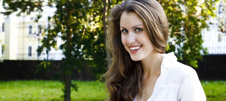 Smiling happy pretty girl in a park