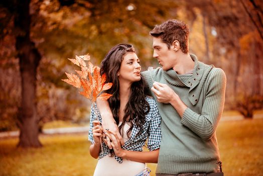 Beautiful lovely couple walking and enjoying in the park in autumn colors.