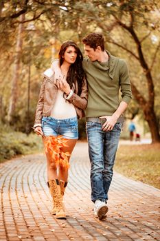 Beautiful lovely couple walking and enjoying in the park in autumn colors.