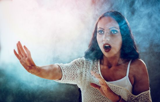 Young stressed woman scared looking through smoke and looking away.