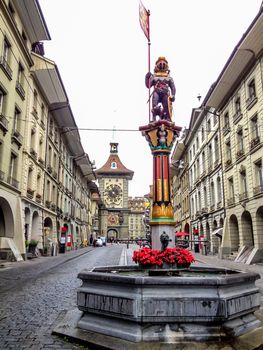 Beautiful City Street View of the colorful medieval Zahringen statue on top of elaborate fountain in Bern, Switzerland. The fountain is attributed to Hans Gieng in 16th century.