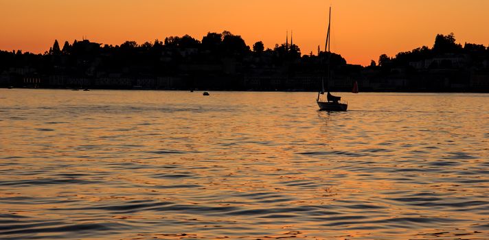 Sailing yacht silhouette at sunset on the lake