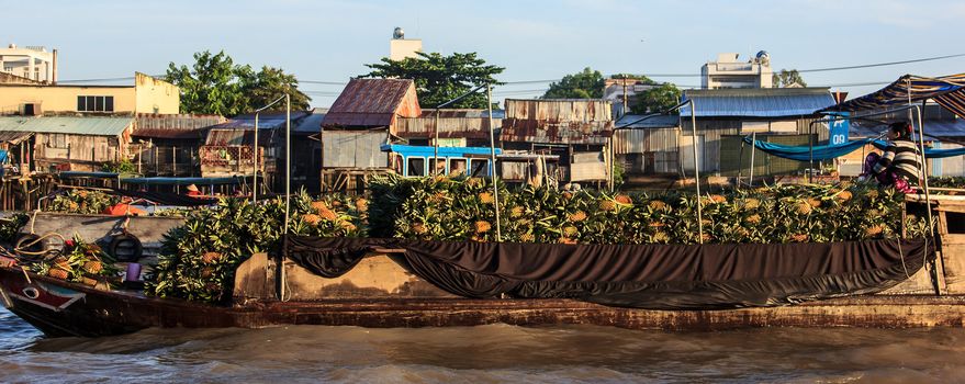 Pineapple Seller riding on the boat in direction of the floating market in Hau River, a distributary of the Mekong river, Can Tho, Vietnam