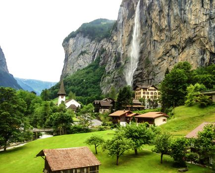 Beautiful Staubbachfall waterfall flowing down the picturesque Lauterbrunnen valley and village in Bern canton, Switzerland, Europe