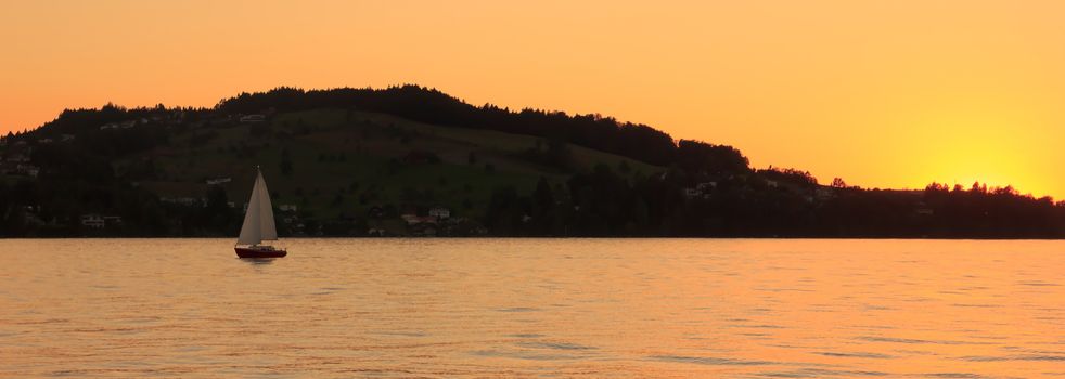Sailing yacht at sunset on the beautiful Lucerne lake, Switzerland